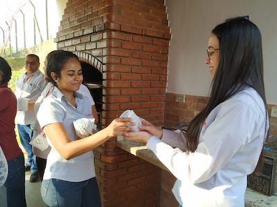 bimeda employee handing out a reusable cup to another woman