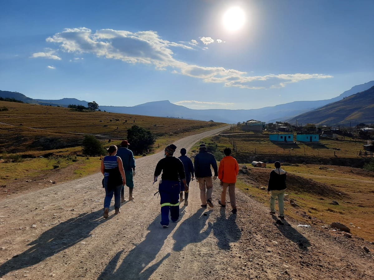group of people walking along a dirt road